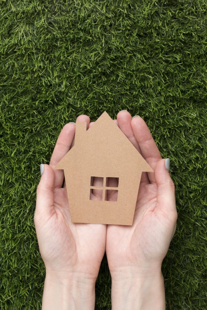 mains avec maison miniature